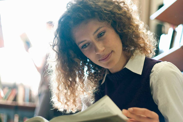 Person with Curly Hair Reading a Book. 