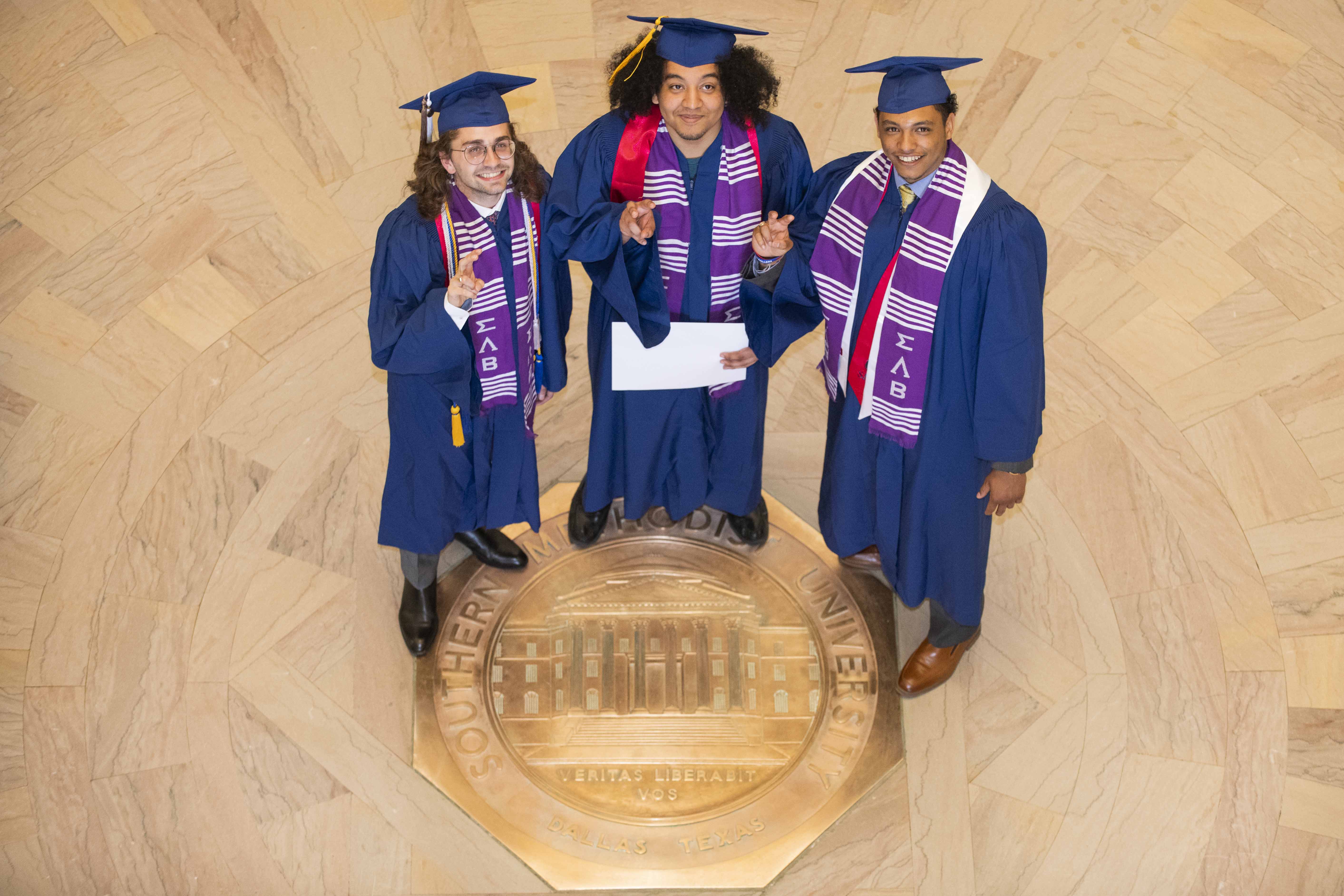students standing on the university seal in the Dallas hall rotunda