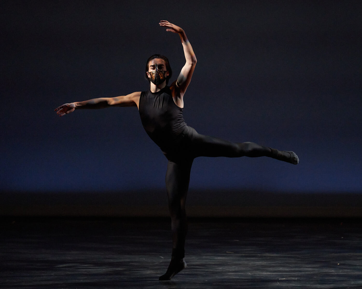 Dancer in black against a black background