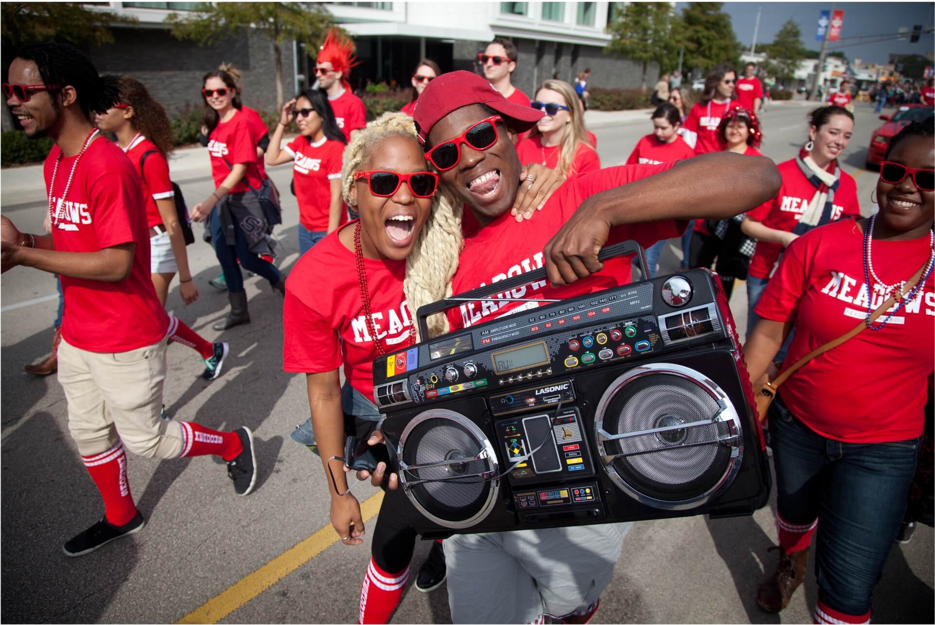 Homecoming students wearing red shirts holding a boombox