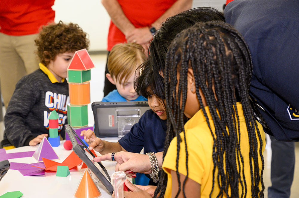 Children at West Dallas STEM School using tablets to build a tower for a geometry project during a visit with Toyota USA Foundation and SMU's Simmons School of Education and Human Development.
