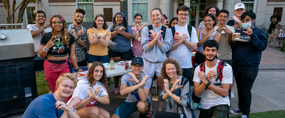 Crum students outside giving the Crum hand sign
