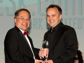 Simon Mak, associate director of the Caruth Institute for Entrepreneurship, presents the Dallas 100 award for fastest growing private company in North Texas to Jason McCann, CEO of Coppell-based VARIDESK.