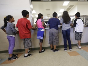 Detained immigrant children line up in the cafeteria at the Karnes County Residential Center. Photo by Eric Gay of The Associated Press courtesy of National Public Radio.