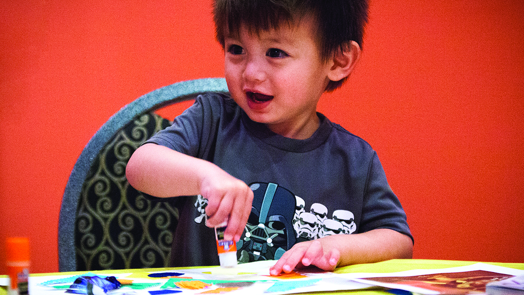 Child participating in arts and crafts activity. 