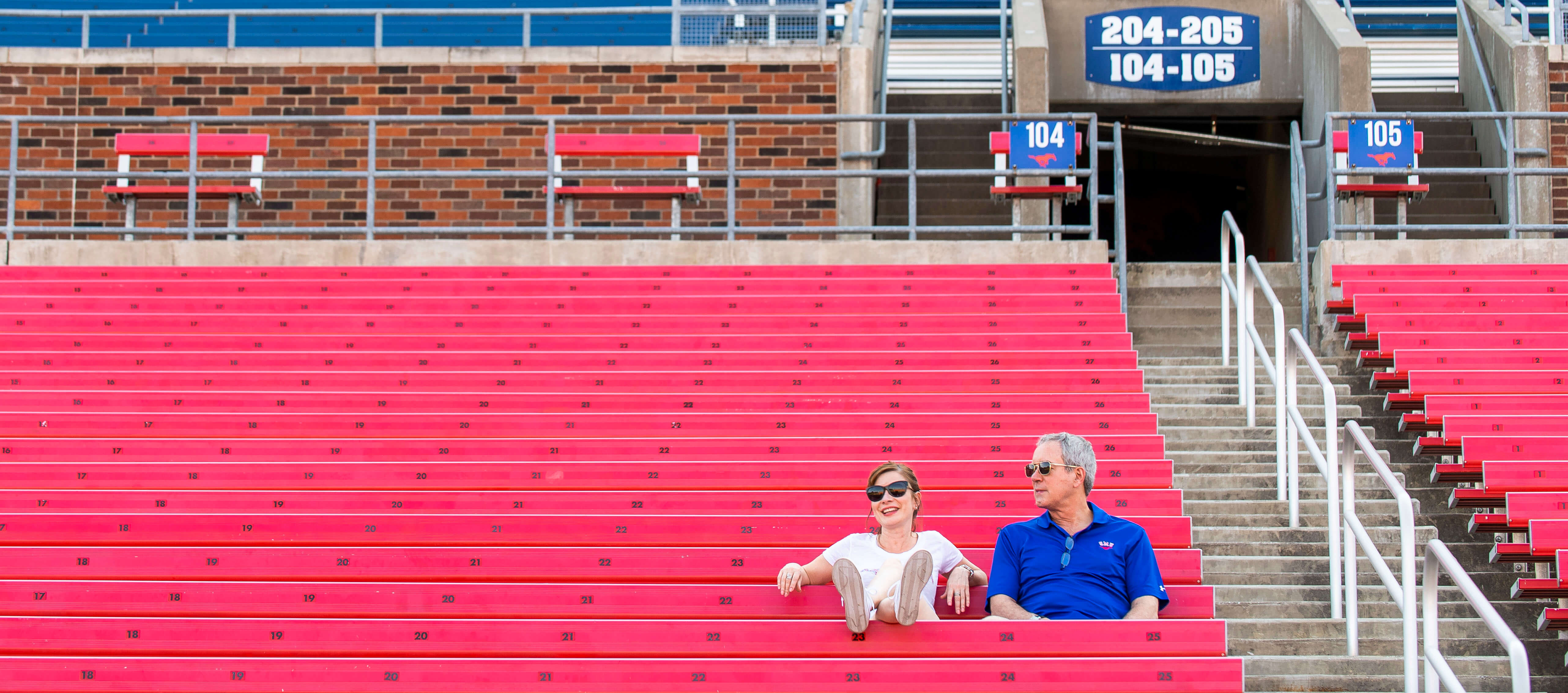 Two people sitting at Ford Stadium