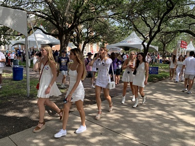 Students wearing white at the first game of the season - walking on Bishop Boulevard