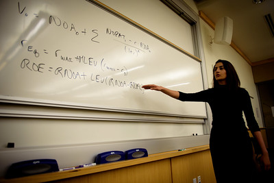 Student at SMU Cox explaining an accounting formula on a whiteboard