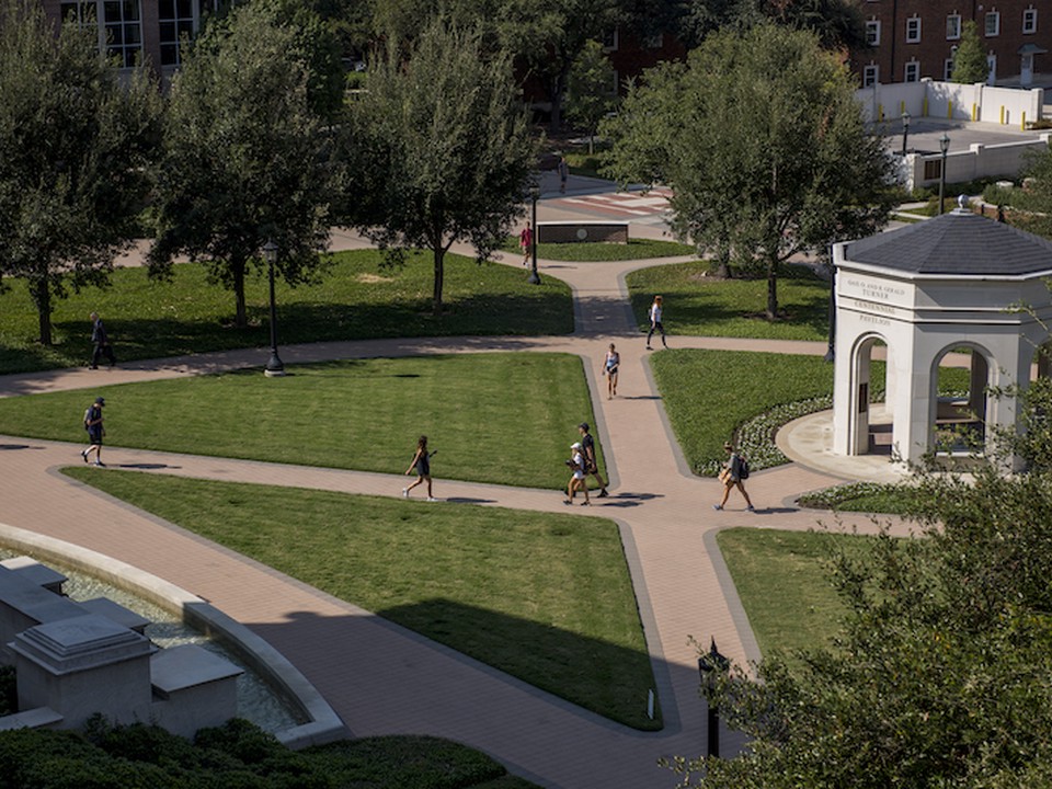 Students walking on the sidewalks next to the gazebo on the SMU Cox campus