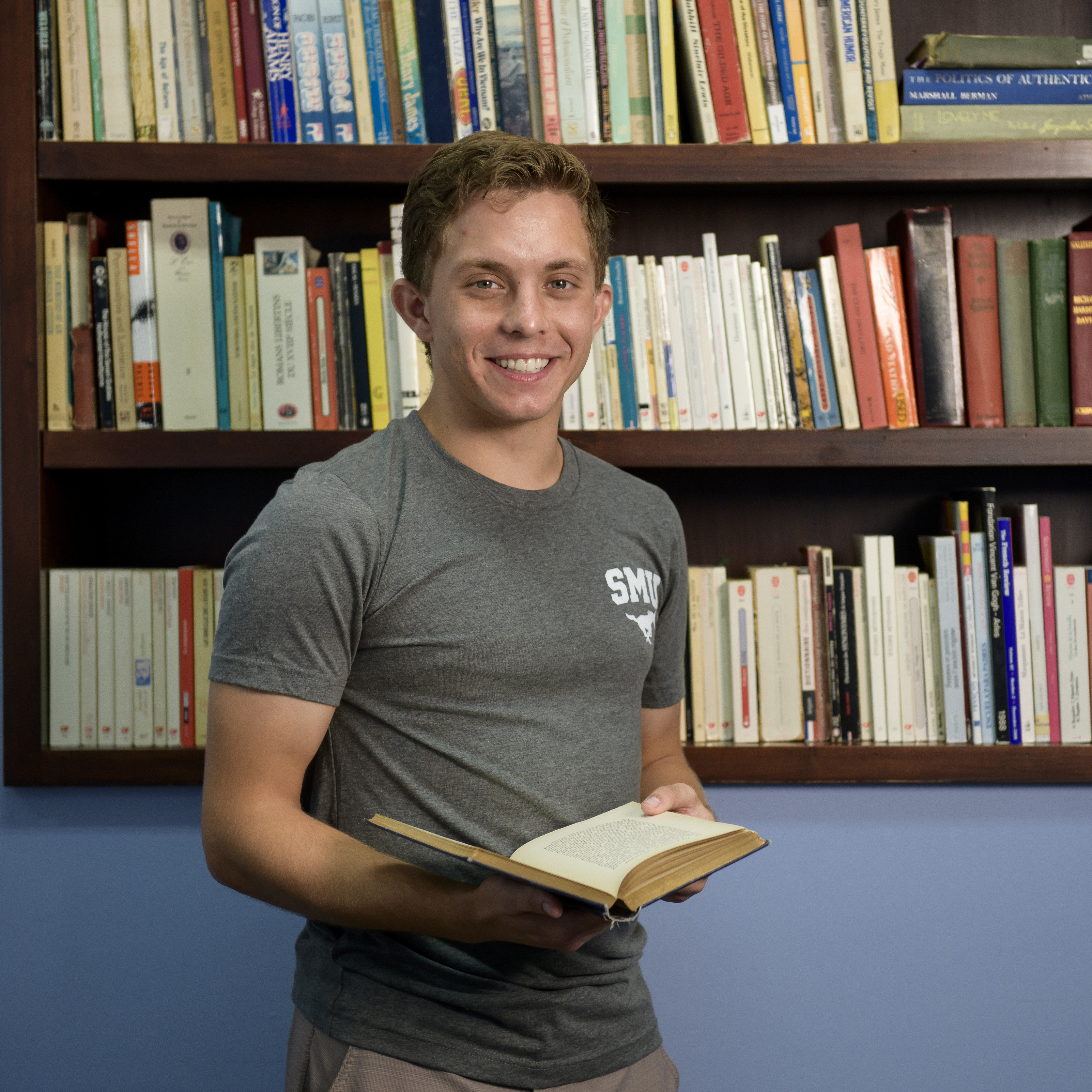 Student Greg Guggenmos Standing Holding Books.