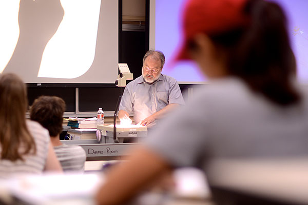 Physics professor teaching in a classroom.