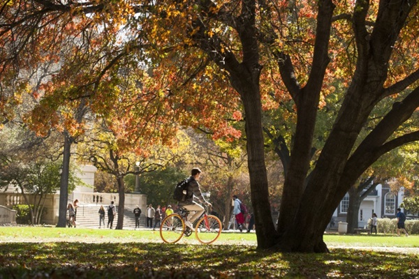 students riding bicycle on campus