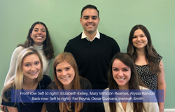 M.S. Organizational Psychology students stand in front of a green wall. Front row left to right: Elizabeth Kelley, Mary Winston Reames, Alyssa Randall. Back row left to right: Fer Reyna, Oscar Guevara, Hannah Smith