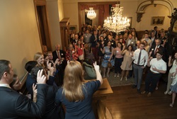 Guests doing a pony up hand sign in Wedding Cake House foyer.