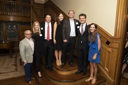 Host committee members stand with Dean DiPiero inside Wedding Cake House on grand staircase.