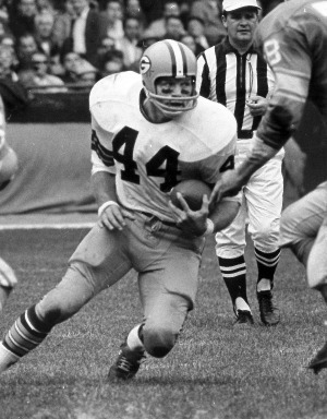 Dynamic snapshot of former Packers running back Donny Anderson in full stride on the football field, demonstrating his remarkable agility as he carries the ball downfield.