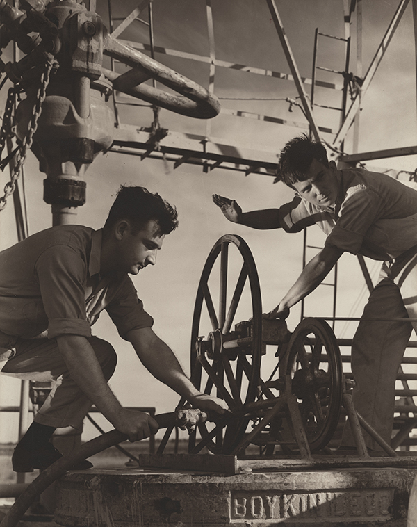 Roughnecks on drilling rig floor with drilling stem, Halliburton, 1939