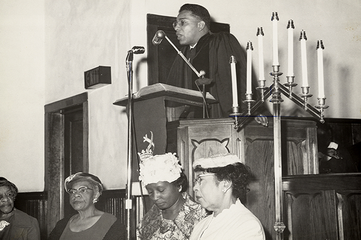 Bishop W T Handy preaching at a pulpit in a church.