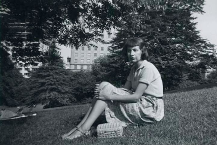 Black and white photo of Amy Clampitt sitting on the ground