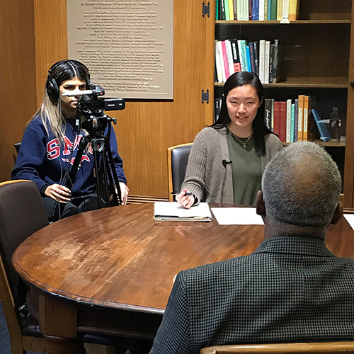 An interviewer and cameraperson conducting an oral history interview for Voices of SMU