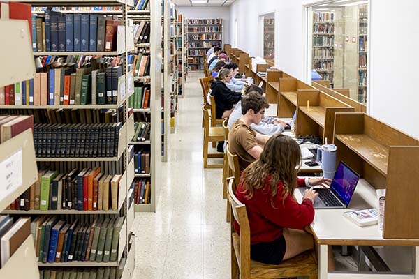 a row of students sitting at study carrels