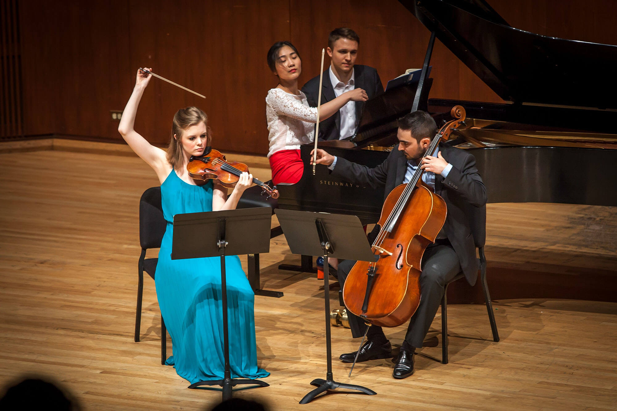 violin, cello, piano trio performing onstage