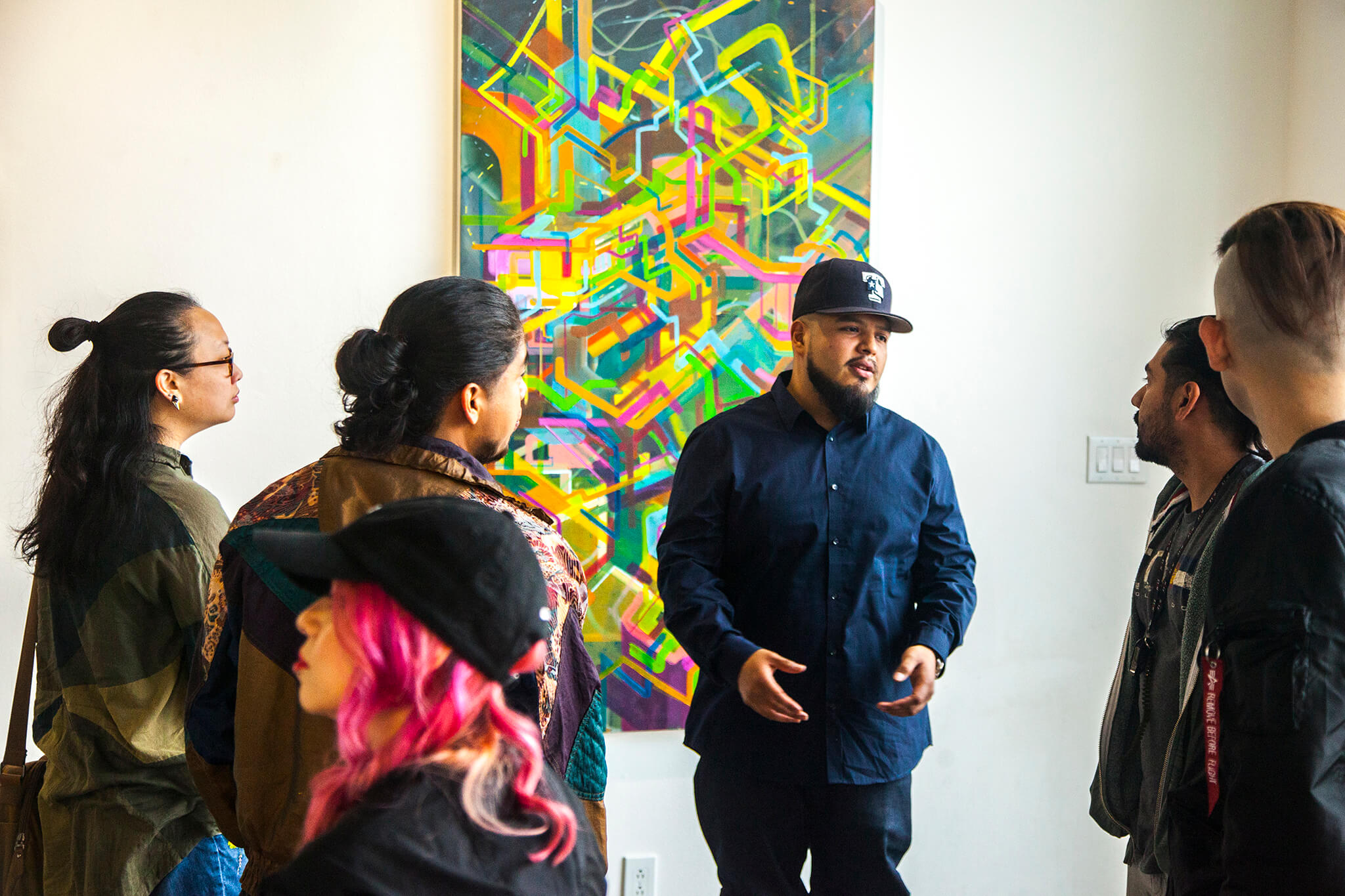 NicolasGonzalez speaks to patrons in front of his art