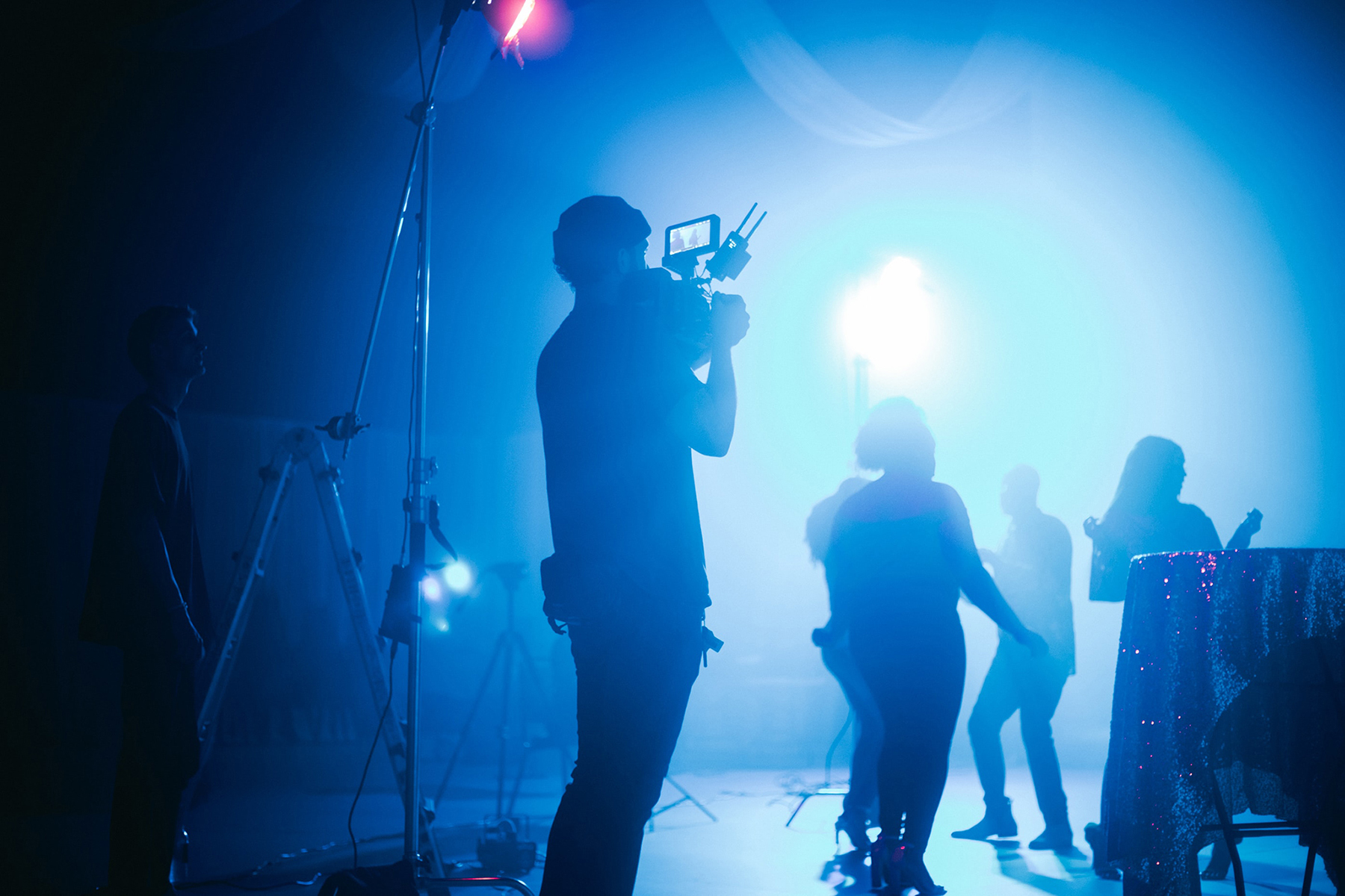 film crew silhouetted against a blue light
