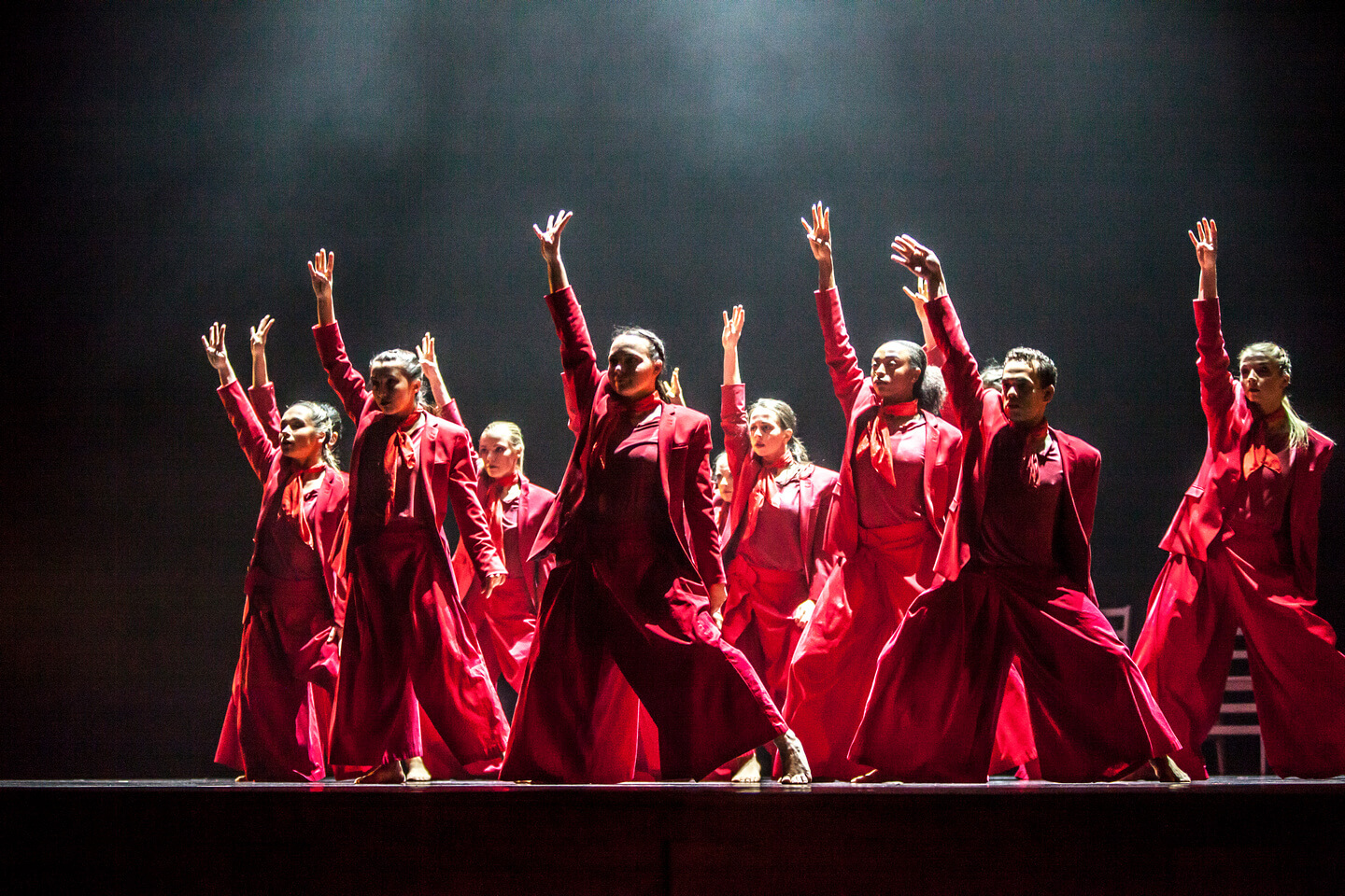 group of female dancers wearing red on a dark smoky stage