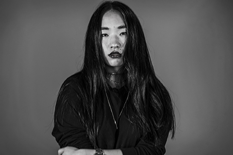 asian girl not smiling in black and white photo on gray background
