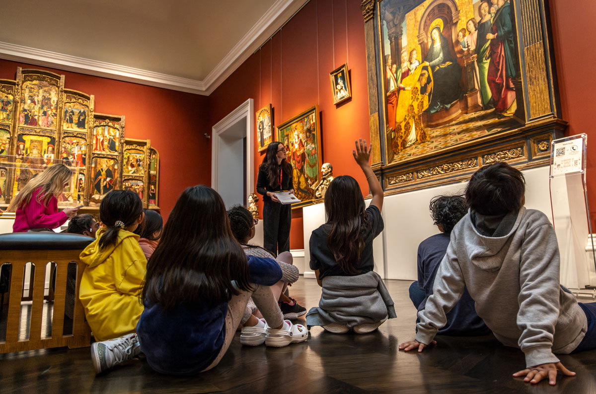 An art history student educates a group of fourth graders on the artwork in the Meadows Museum.