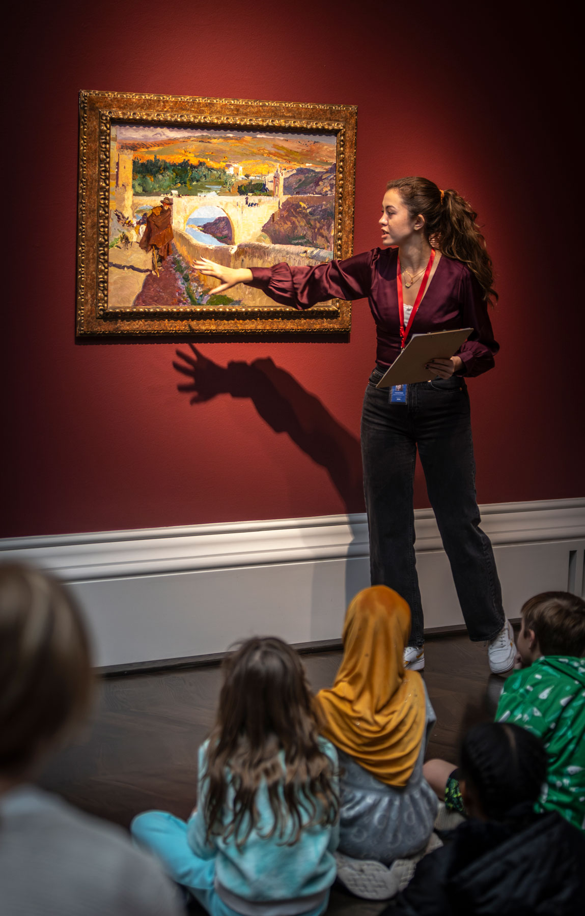 An art history student educates a group of fourth graders on the artwork in the Meadows Museum.