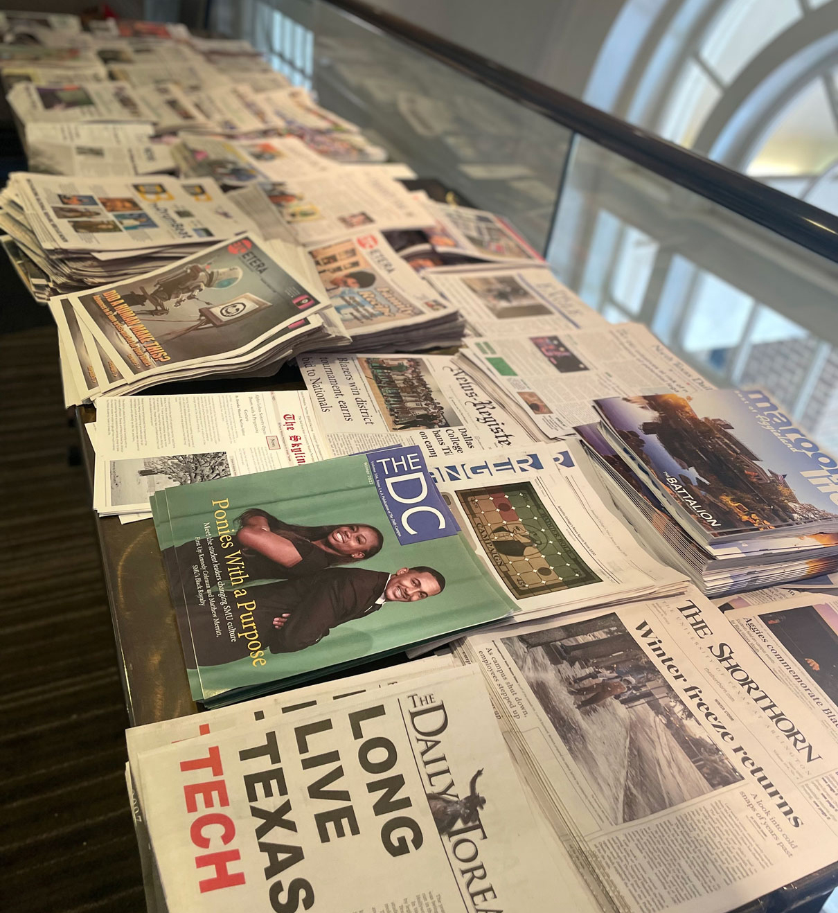 Student publications from across Texas fill a long table at TIPA contest