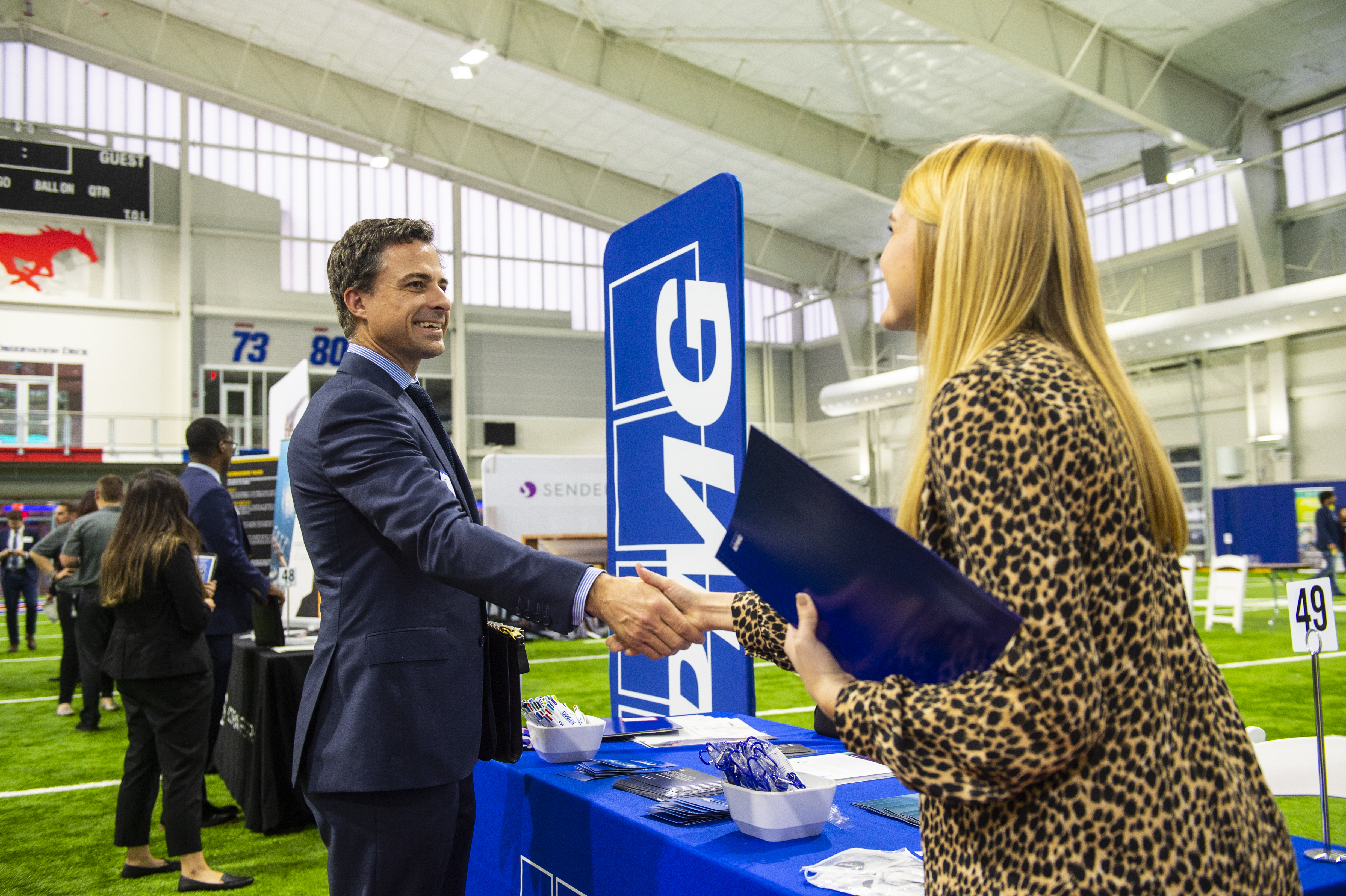 Recruiter and student shaking hands at a company booth