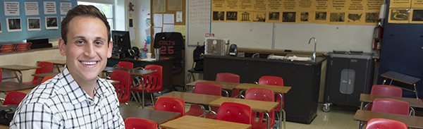 Teacher posing in an elementary/middle school classroom.