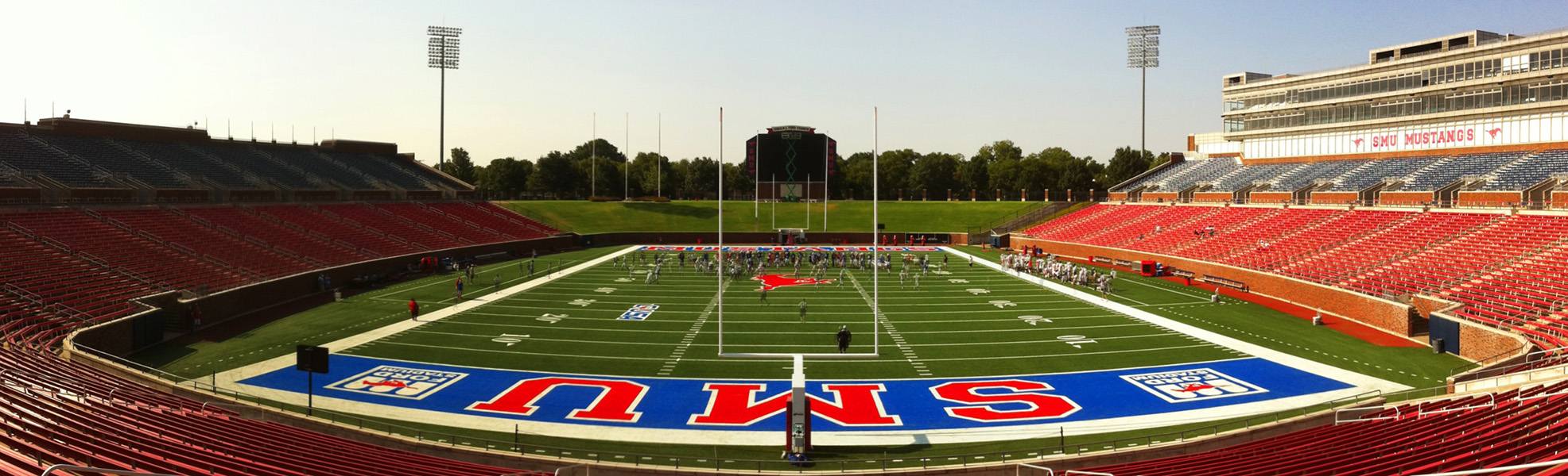 Gerald-J-Ford Stadium, on a cloudless-blue day, with the SMU Mustang football team practicing on the field