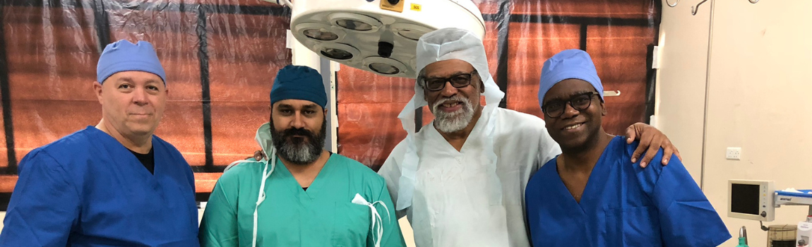 Four men in scrubs in operating room