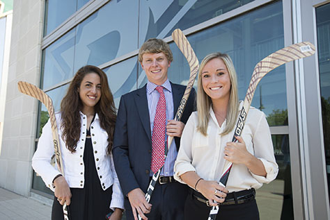 Sports Management students w/ hockey sticks at Dallas Stars Headquarters