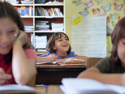 Children working on reading assignments in classroom environment.