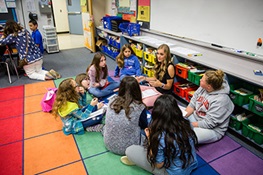 Teacher seated in a circle with students