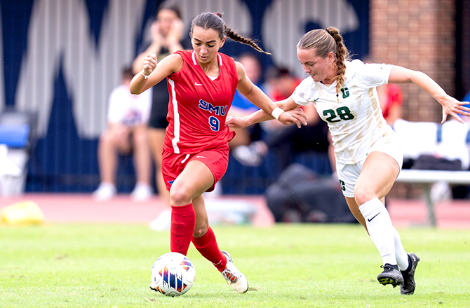SMU Women's soccer player charging down field with the ball