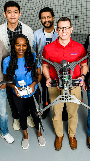 Students posing with a drone