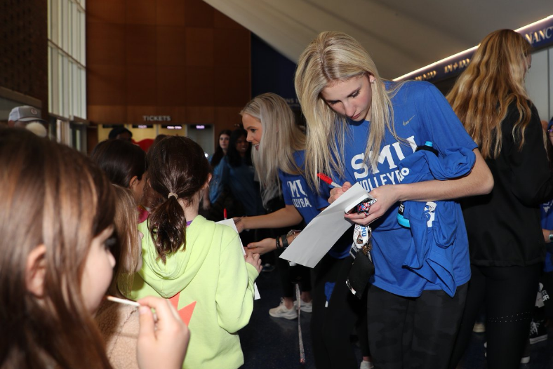 SMU volleyball players signing autographs