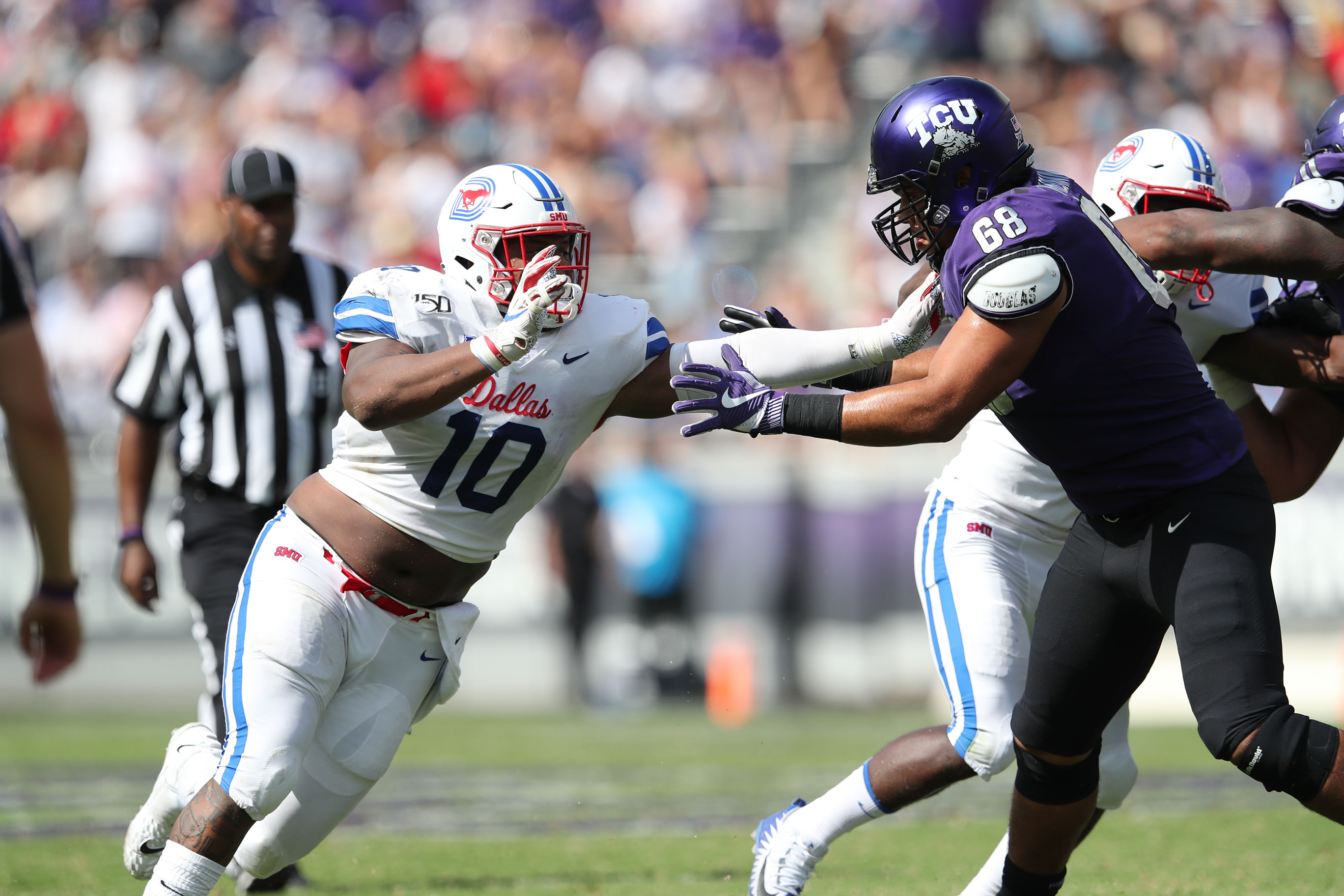 SMU football player (defense) looks to move passed a TCU offensive lineman.
