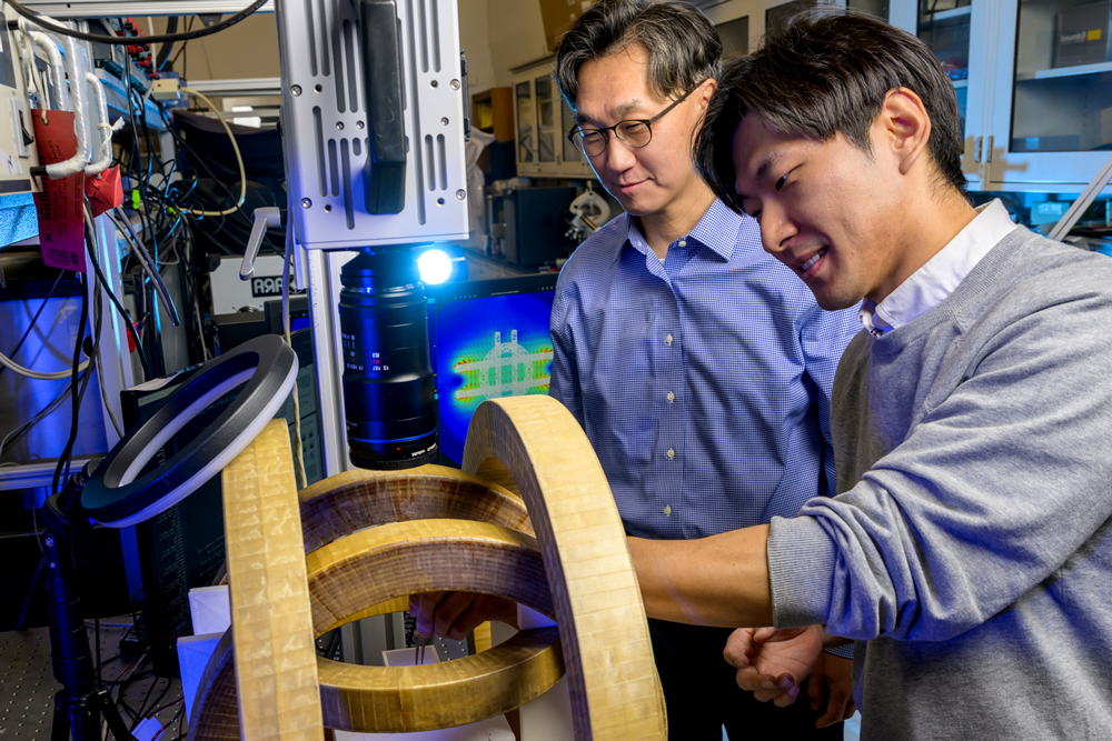 Two researchers work together on equipment in a laboratory.