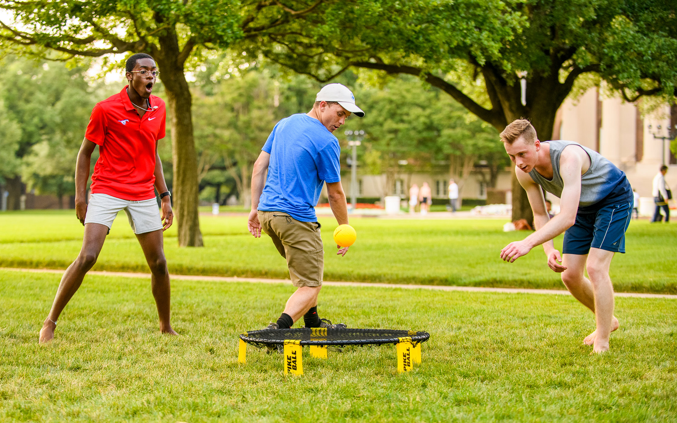 Three SMU students playing a game outside