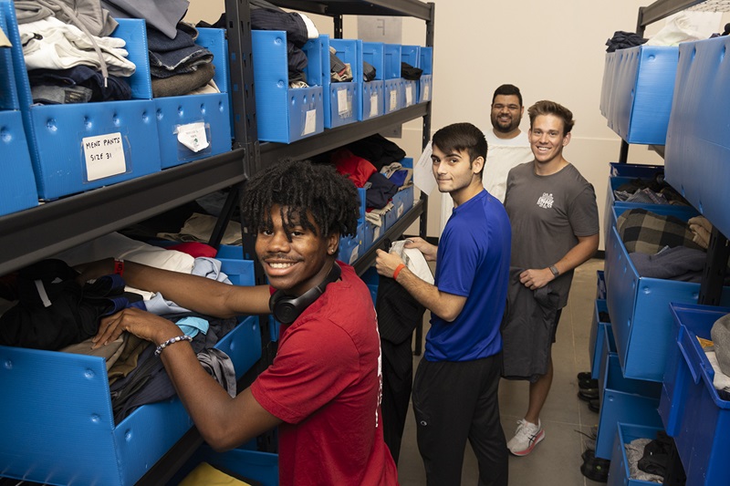 SMU students sort clothes on an Engage Dallas project
