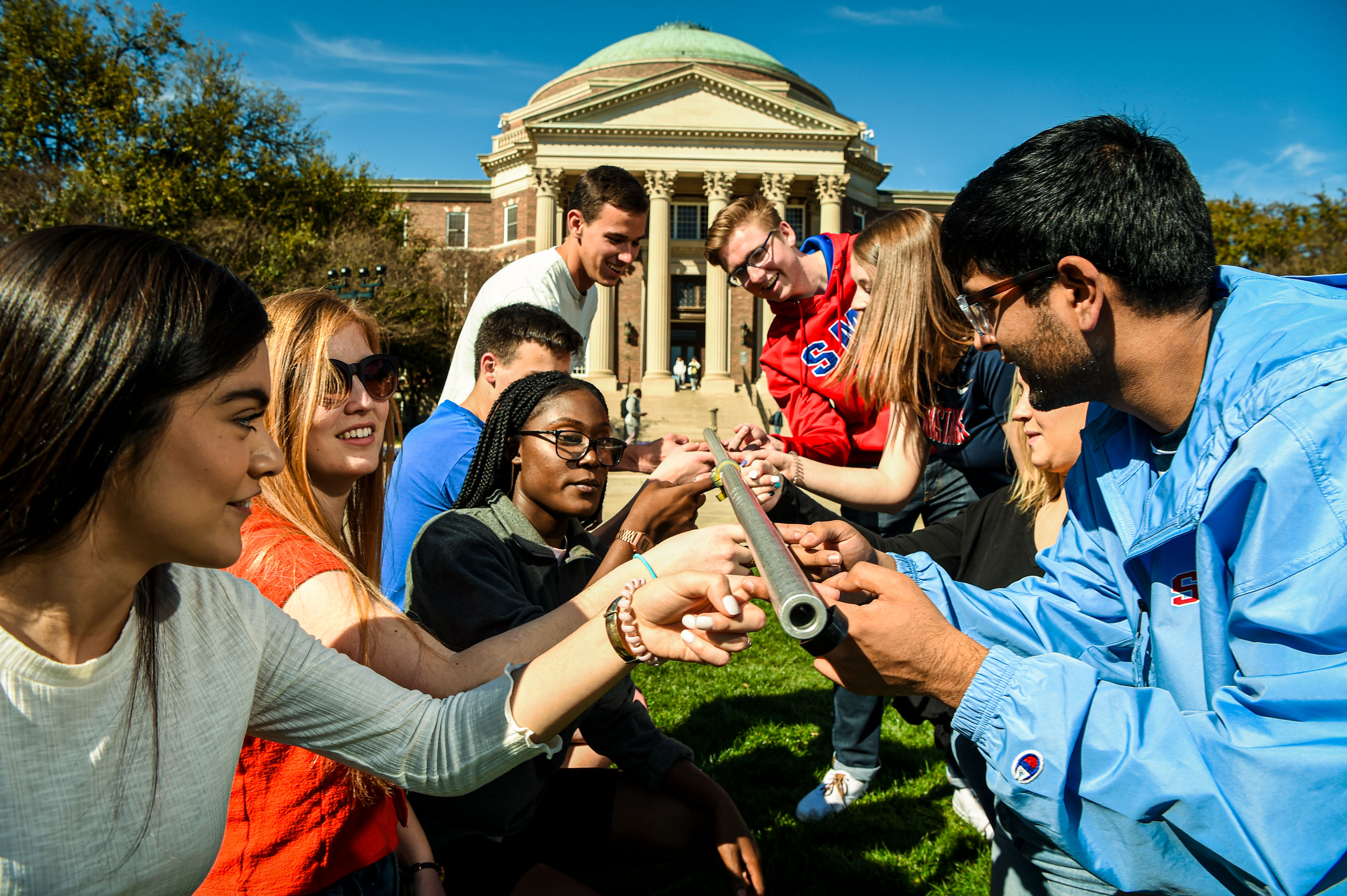 Students working together during a team building activity on Dallas Hall lawn.