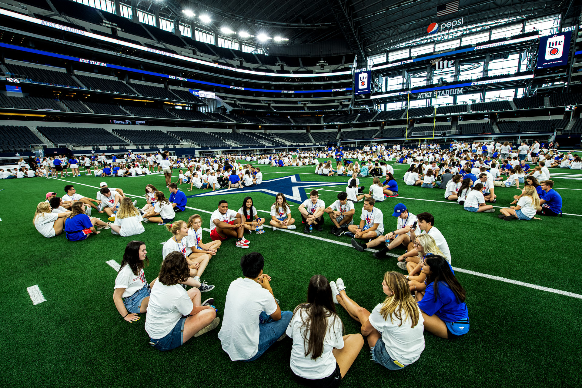 Students in small groups at Cowboys Stadium during Stampede