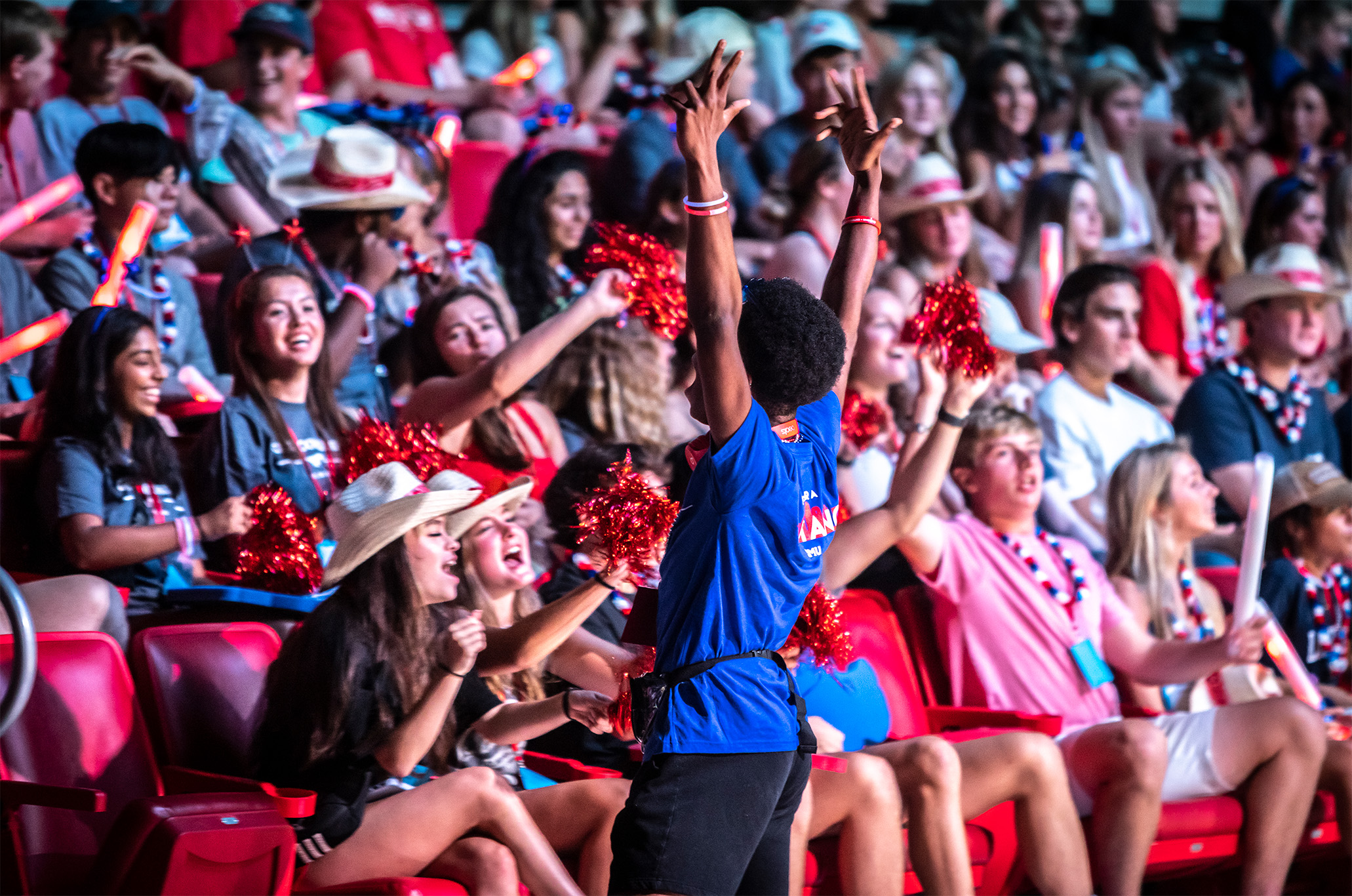 students in Moody Coliseum during Stampede summer 2023 having fun with hands in the air
